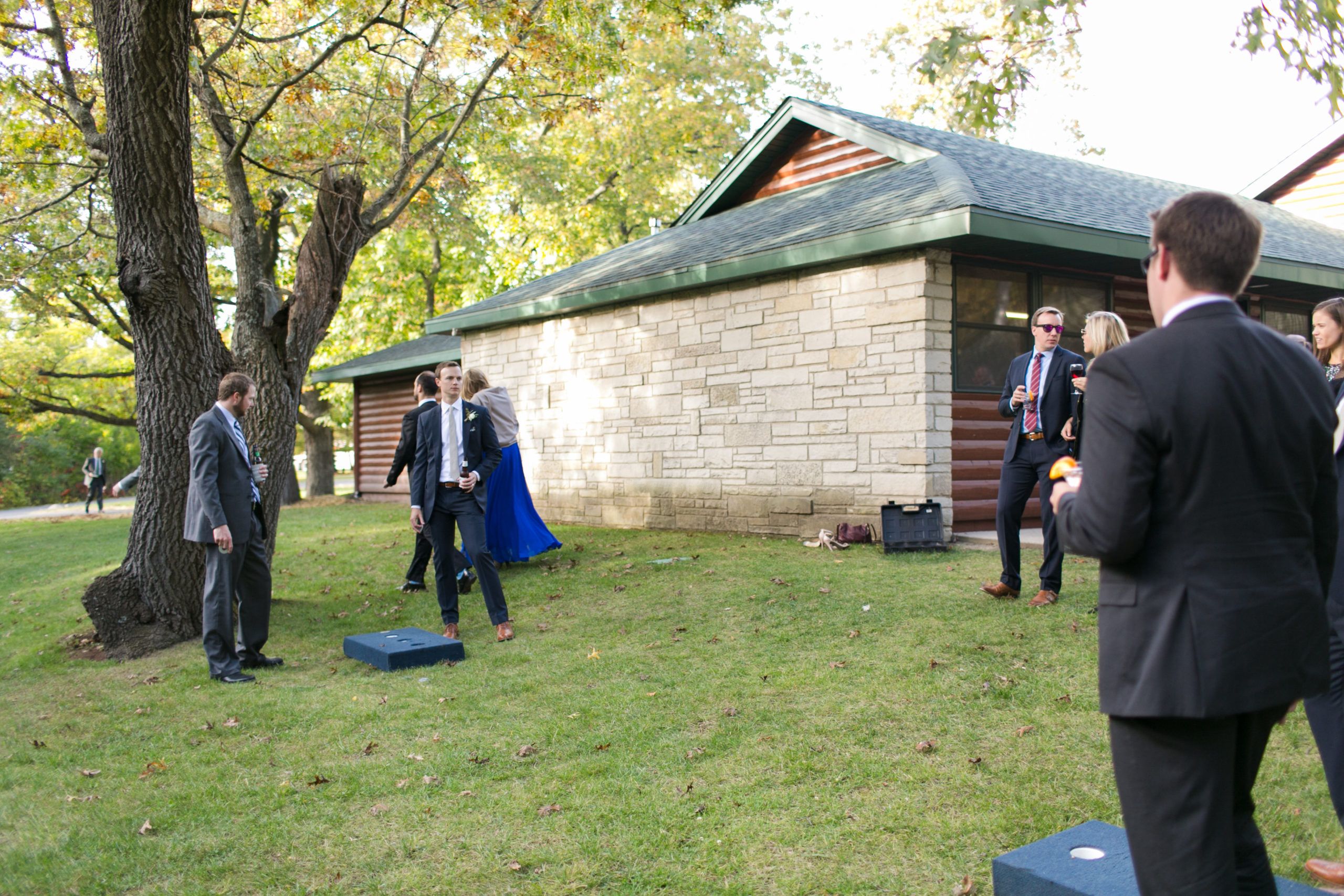 Wedding guests play cornhole and drink | PartySlate