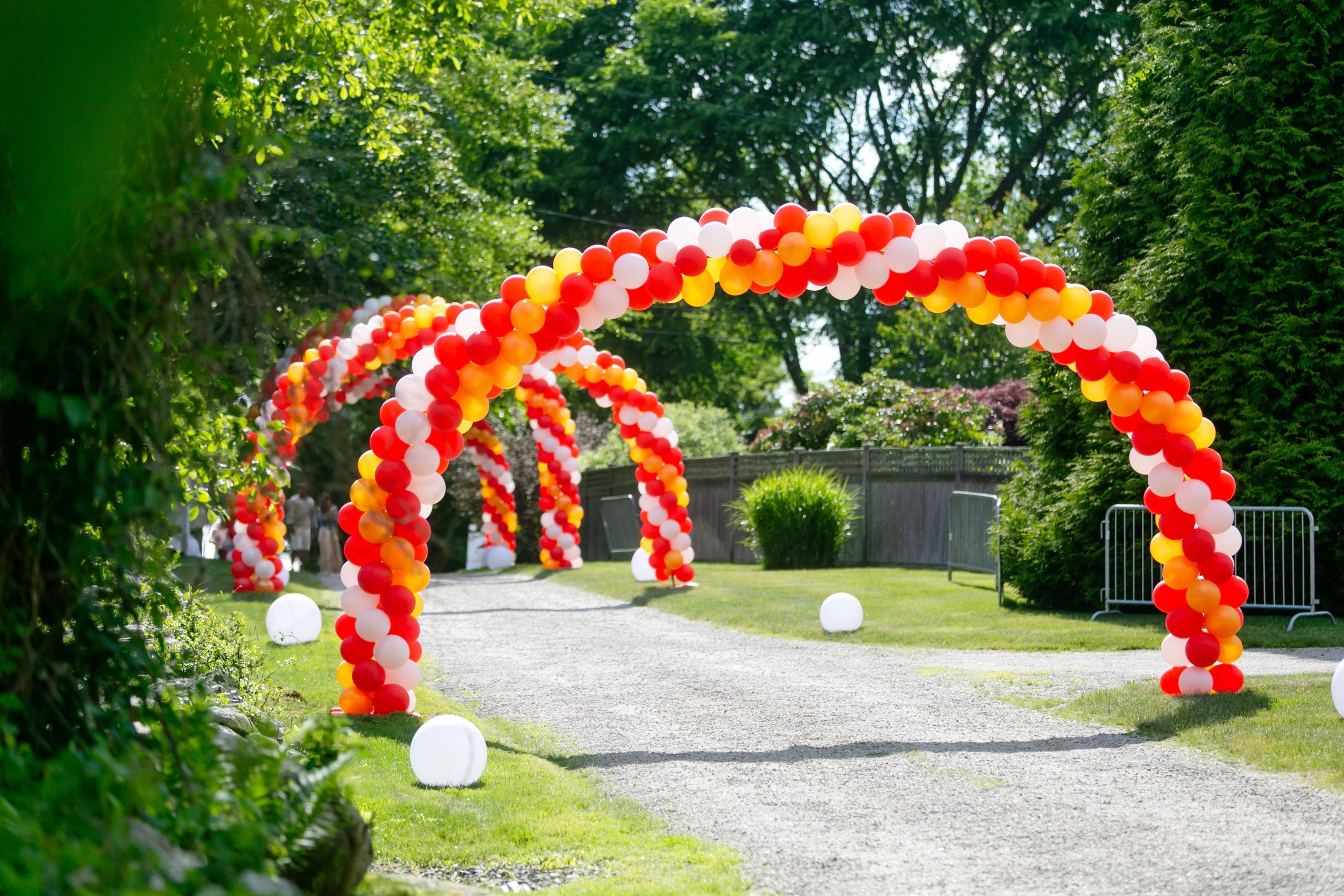 balloon arch entry way over driveway to backyard graduation party | PartySlate