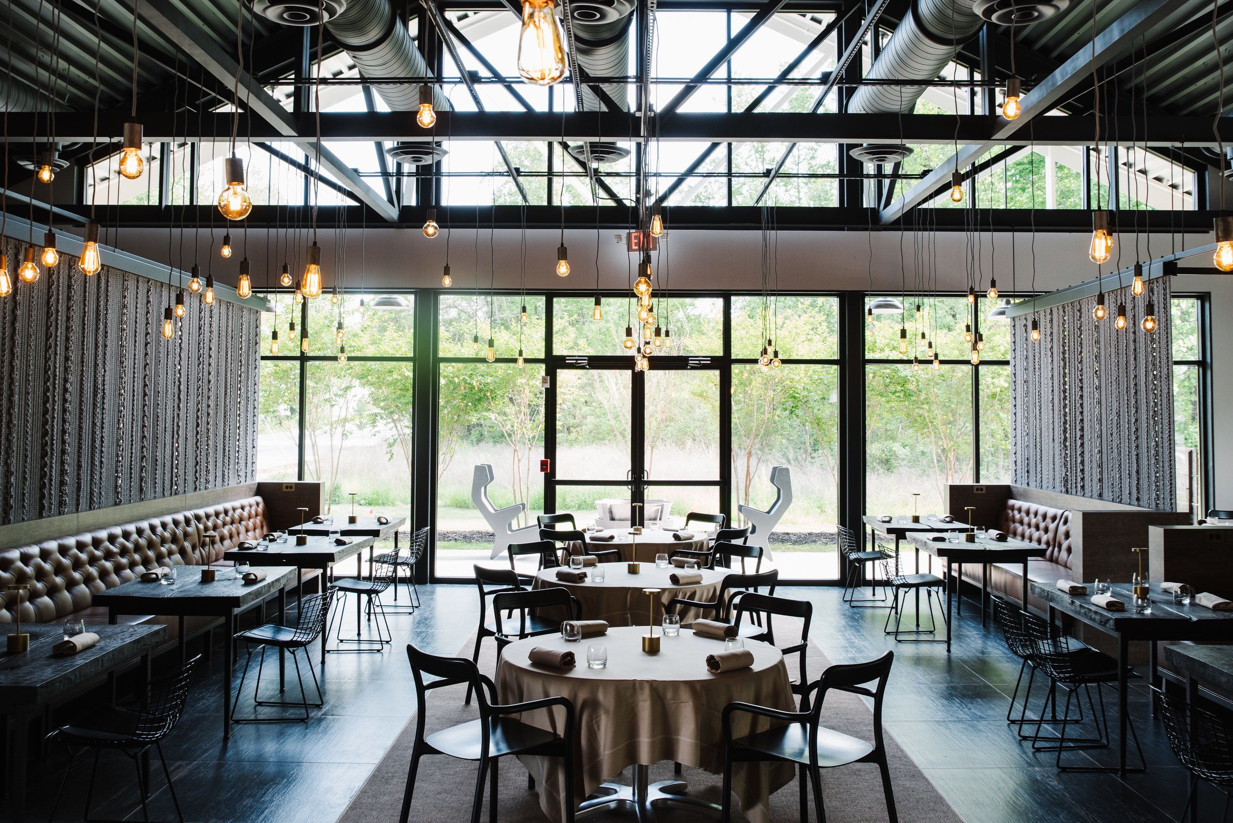 Bacchanalia restaurant in Atlanta with string lights hanging from celling and tables set | PartySlate
