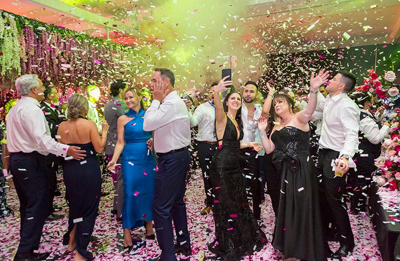 Wedding dance floor filled with people and confetti while Power Parties DJ's, Lighting and Hora Locas djs | PartySlate