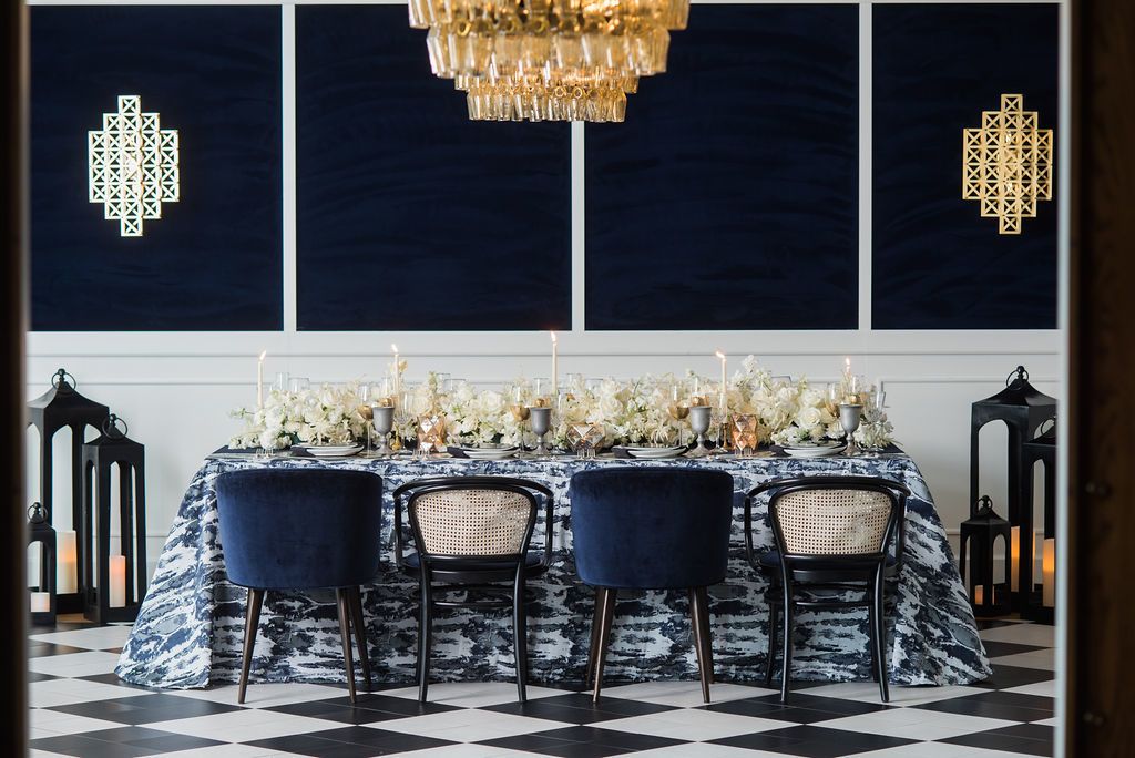 Dinner party at Del Mar in Washington D.C. with floral centerpieces and blue accents within the space | PartySlate