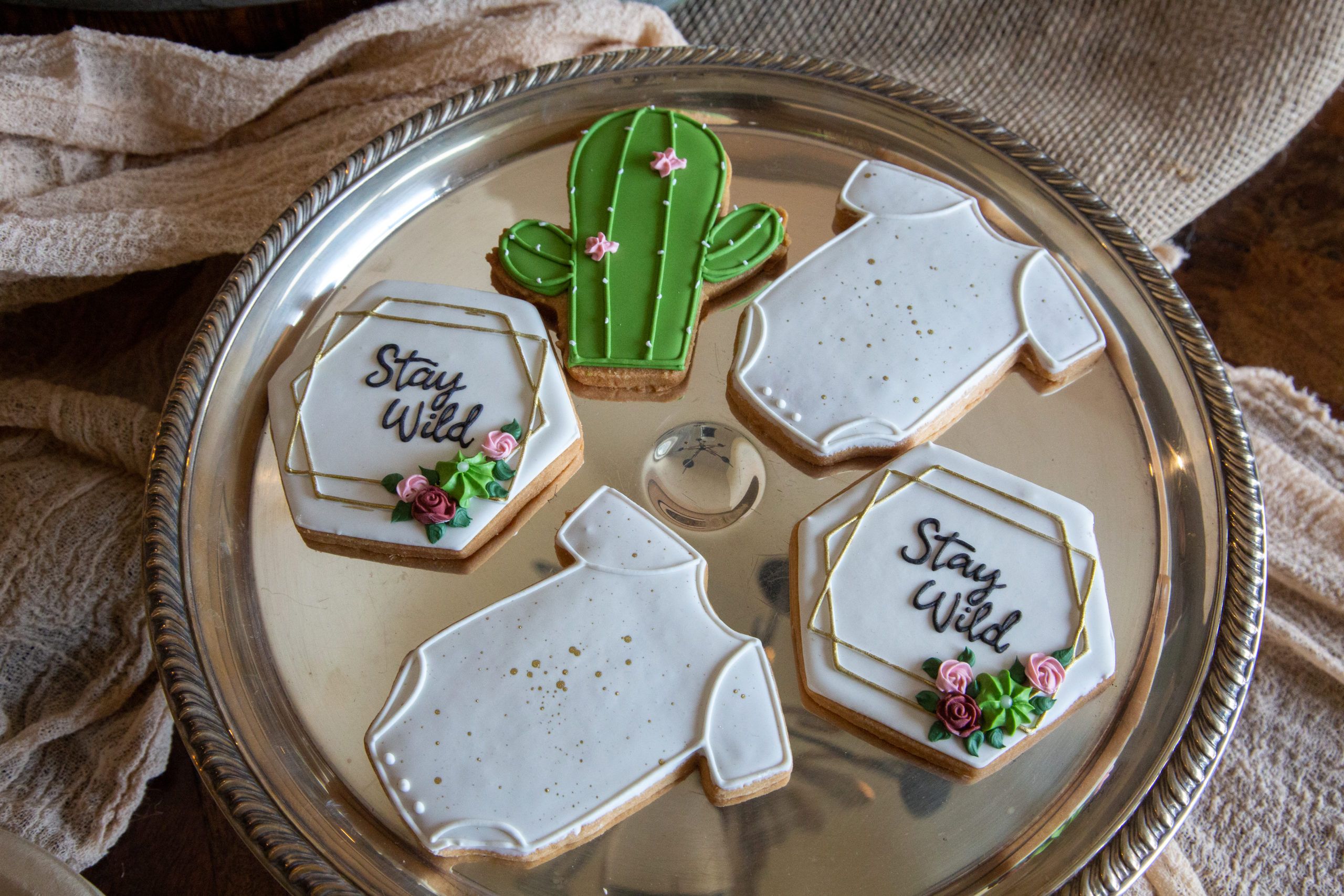 onesie and cactus shaped cookies at western themed baby shower | PartySlate