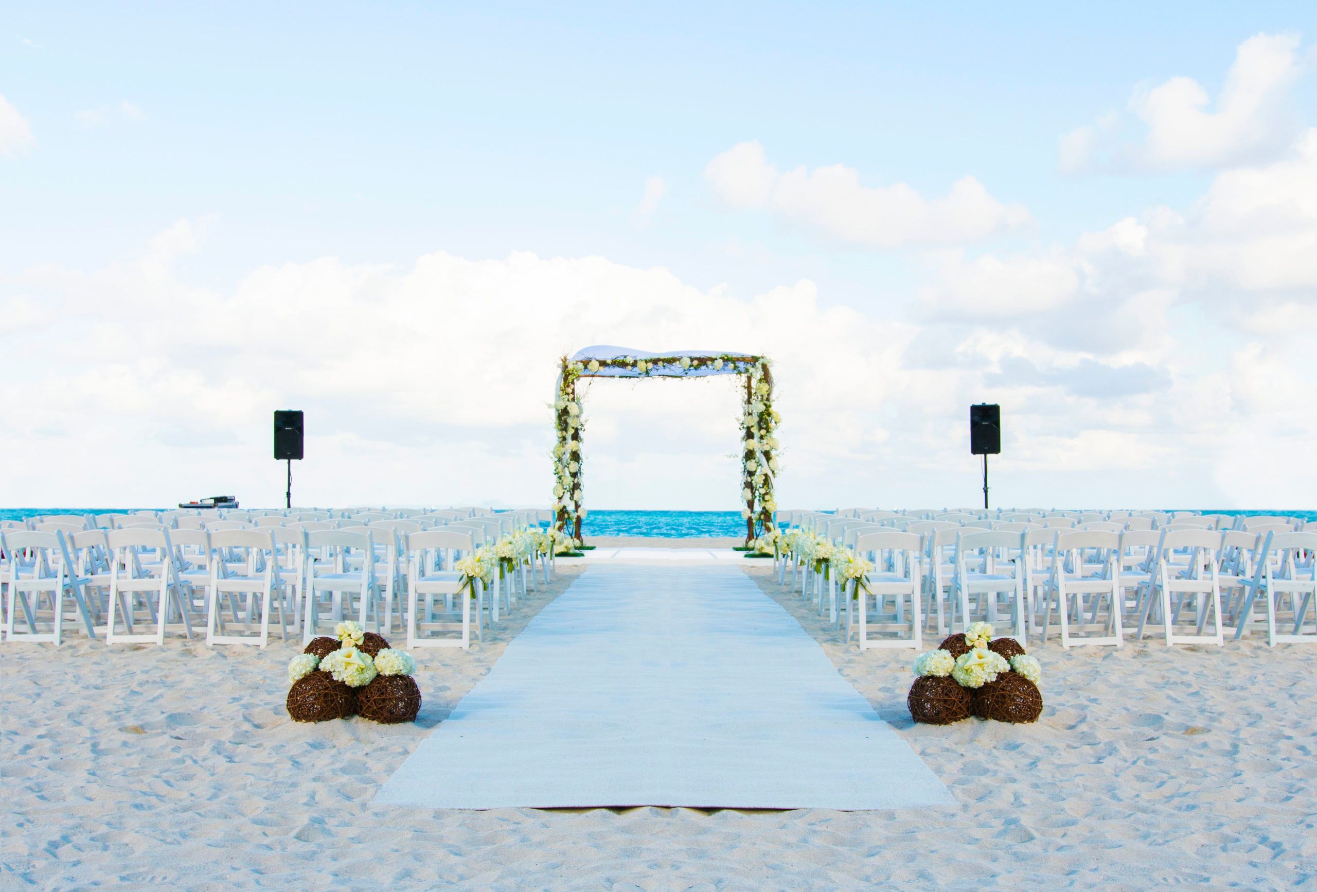 Private beach event and wedding space at the bath club miami set up with florals and wedding arch | PartySlate