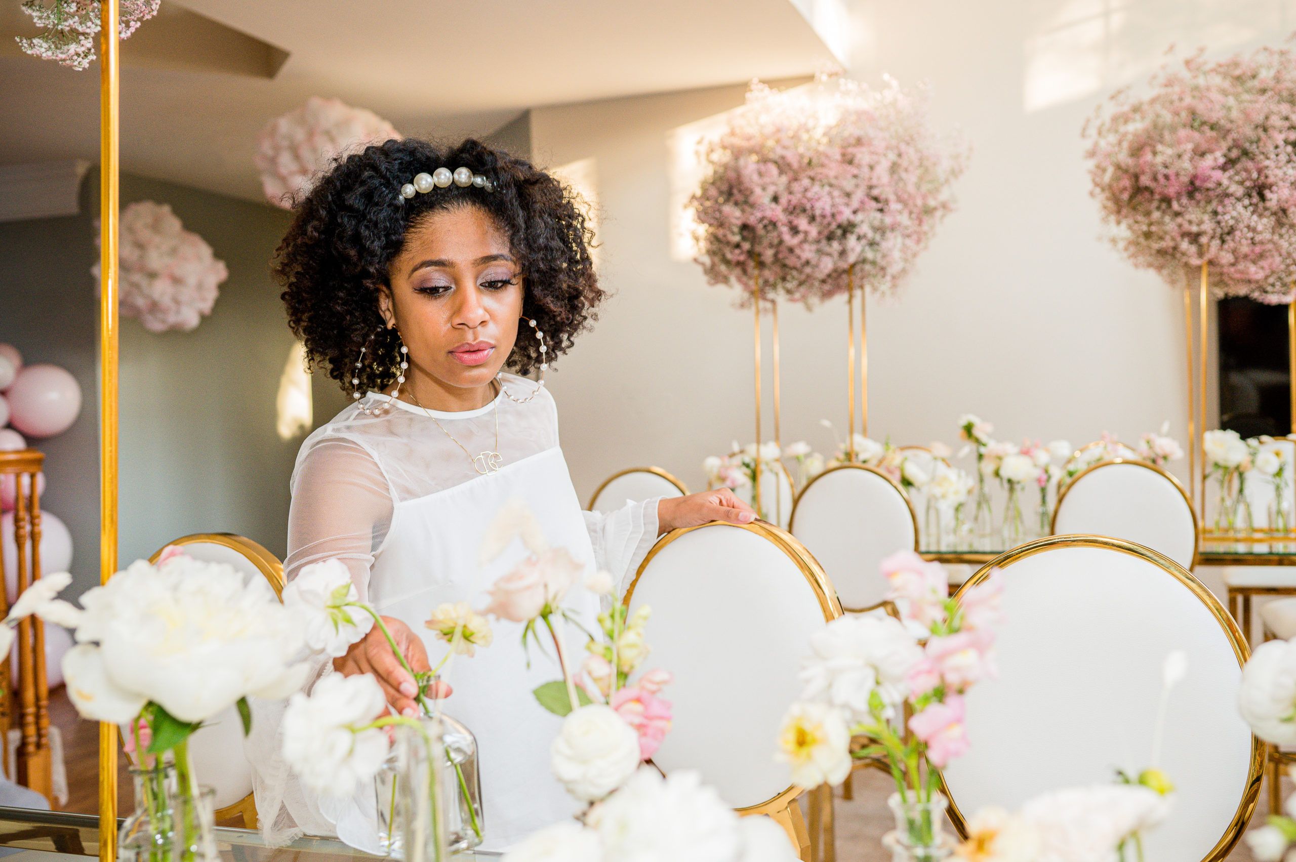 Event planner arranges flowers at whimsical baby shower with floating mauve baby's breath centerpieces | PartySlate