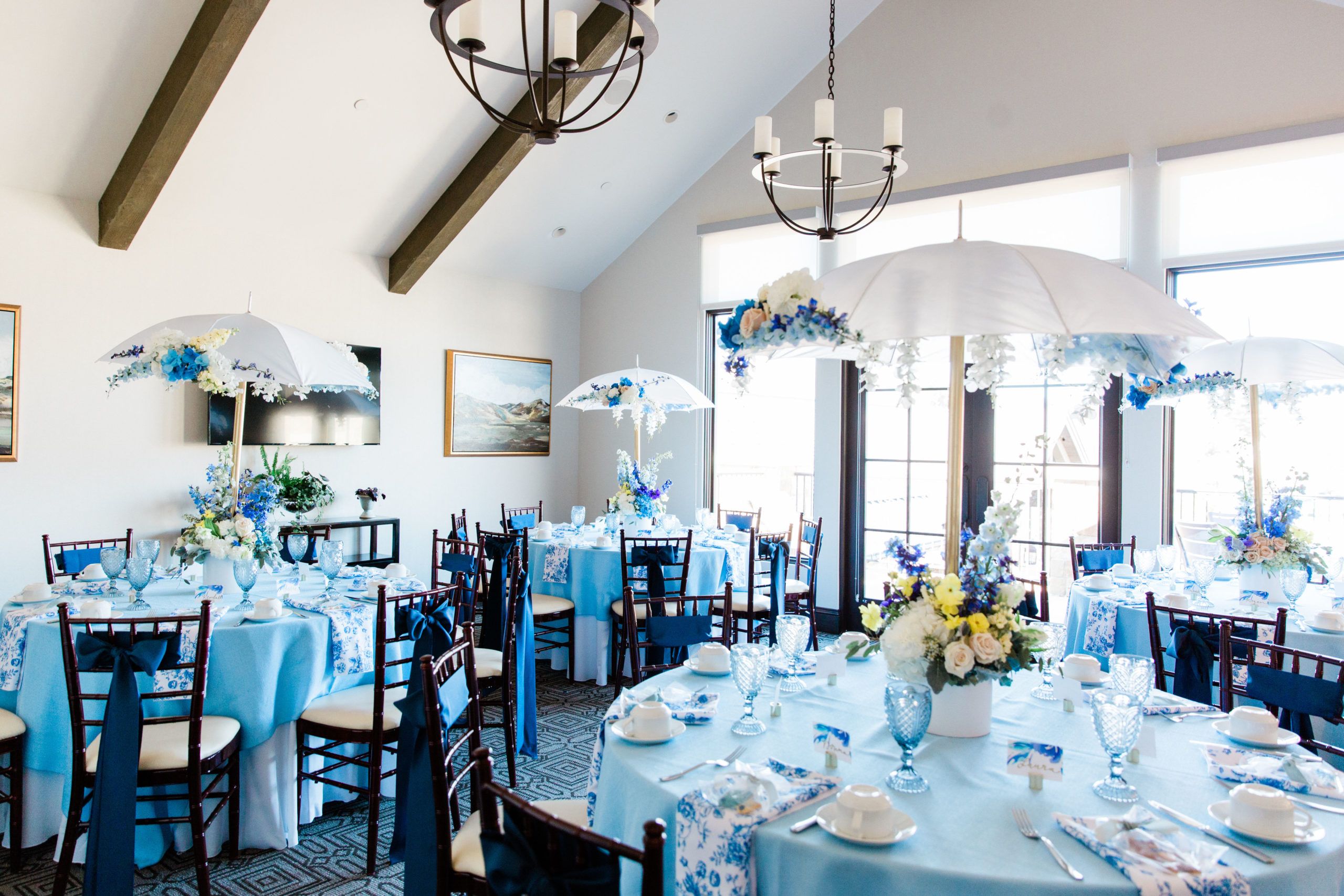 Rain themed baby shower with umbrella centerpieces and blue and white color palette | PartySlate