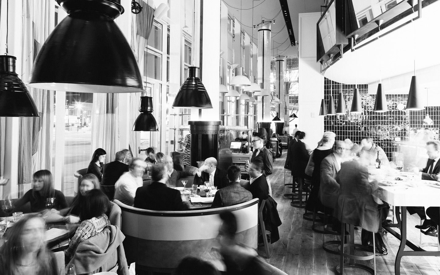 black and white photo of St. Cecilia restaurant in atlanta gorgia with guests seated and eating | PartySlate