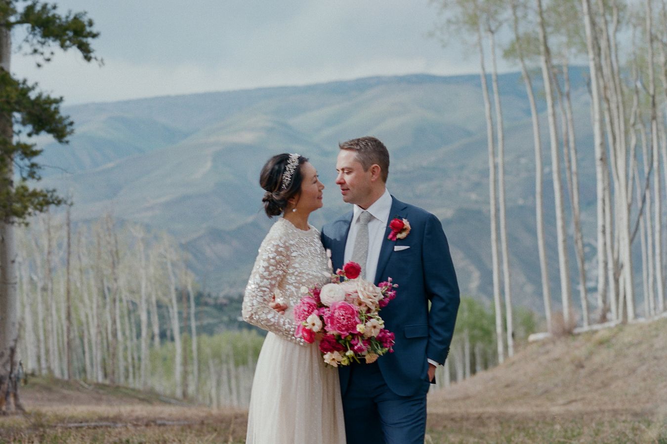 outdoor wedding in vail bride and groom standing in front of mountainous scenery | PartySlate
