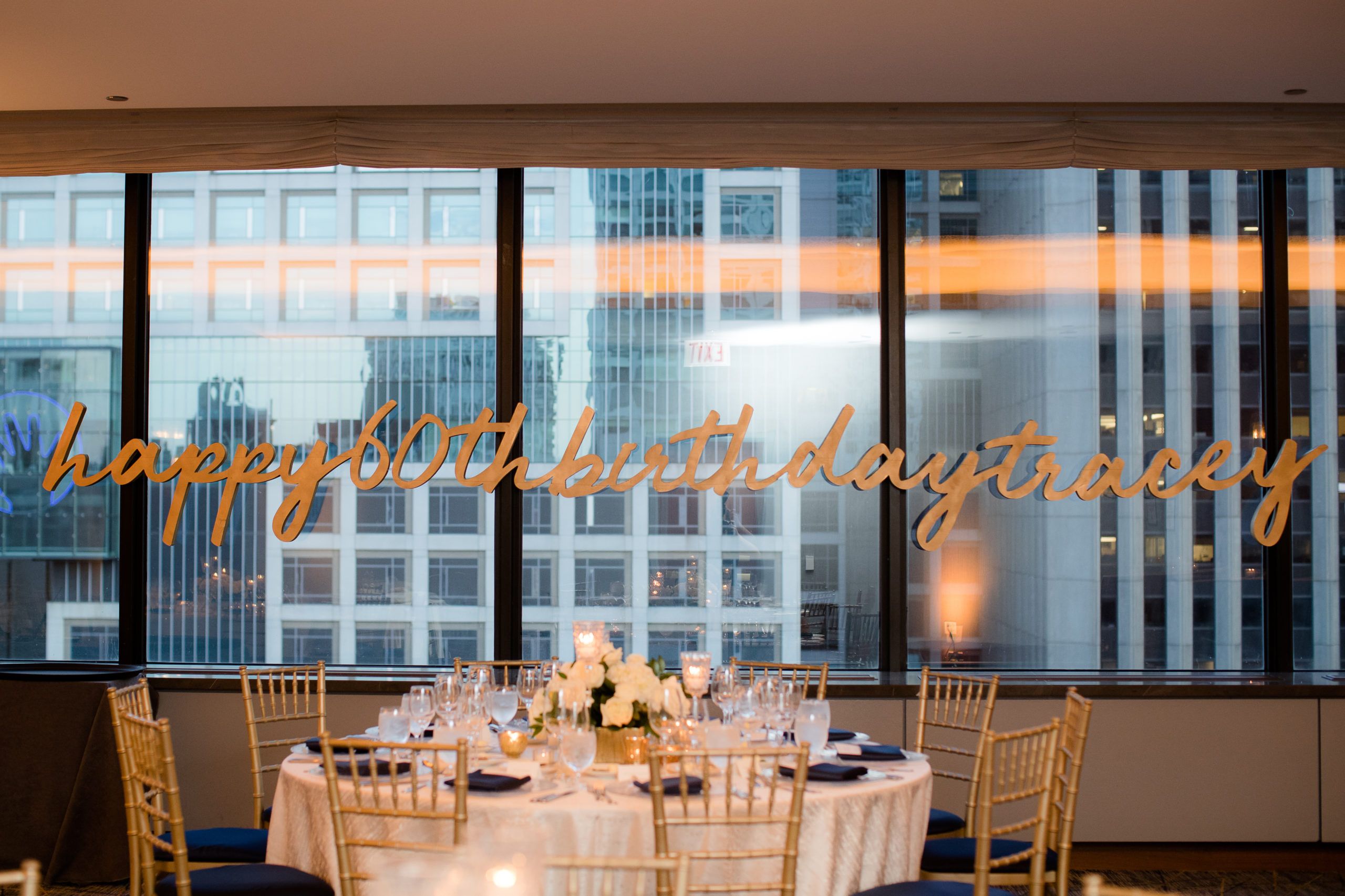 60th birthday signage hanging on inside window of event venue | PartySlate