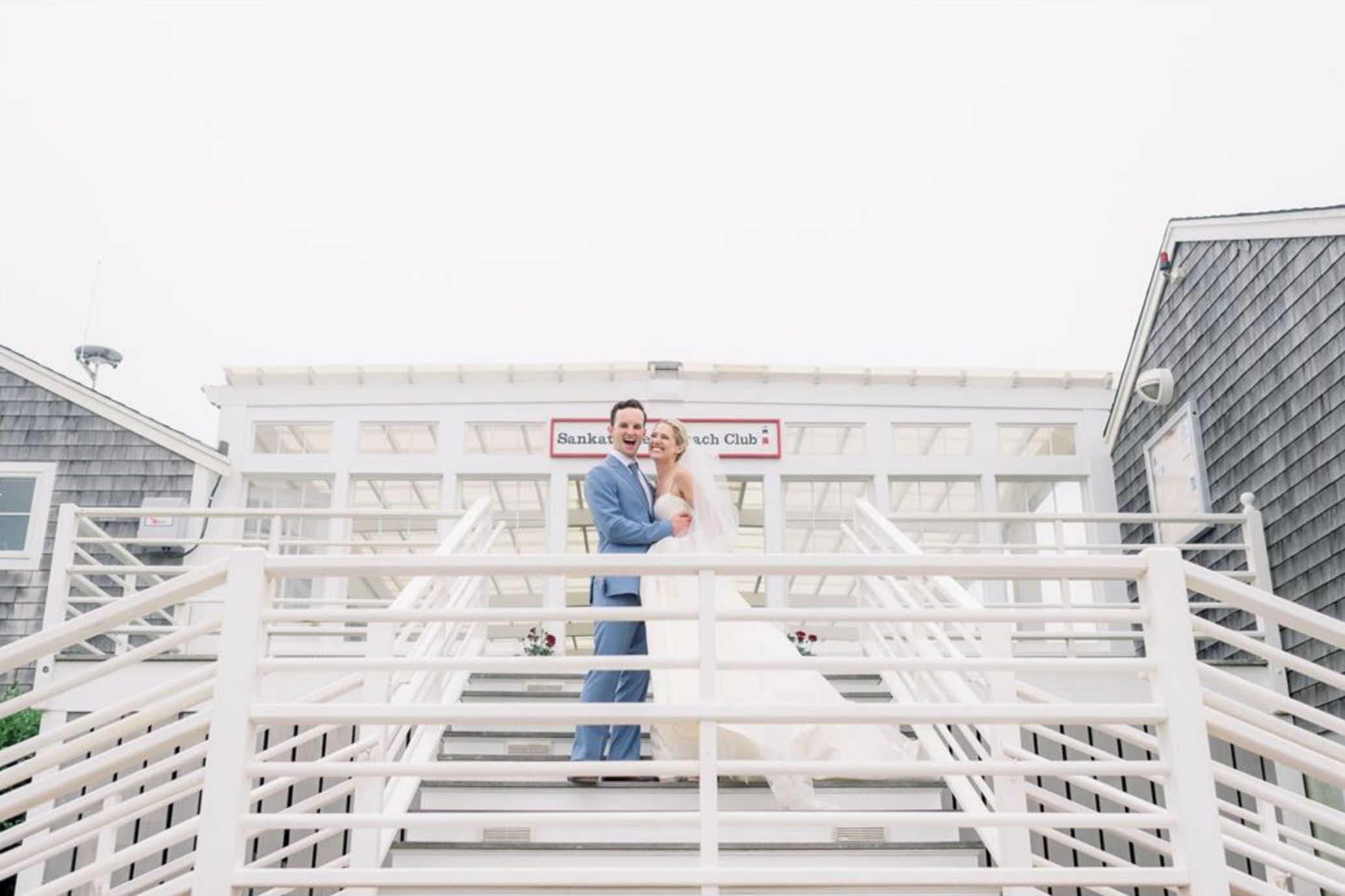 nantucket wedding at The Sankaty Head Beach & Golf Club with couple standing on stairs | PartySlate