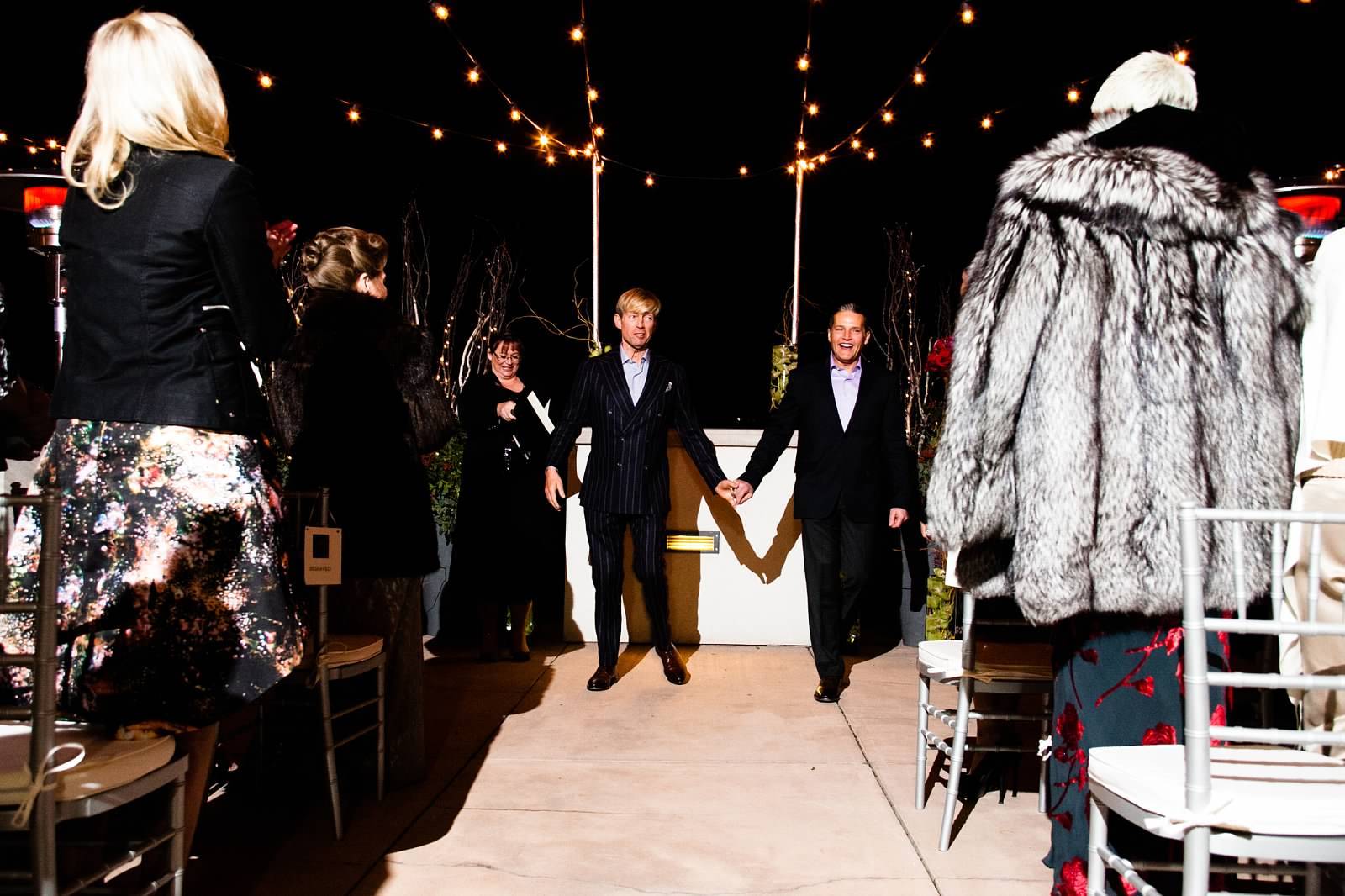 nightime wedding with grooms holding hands at alter | PartySlate