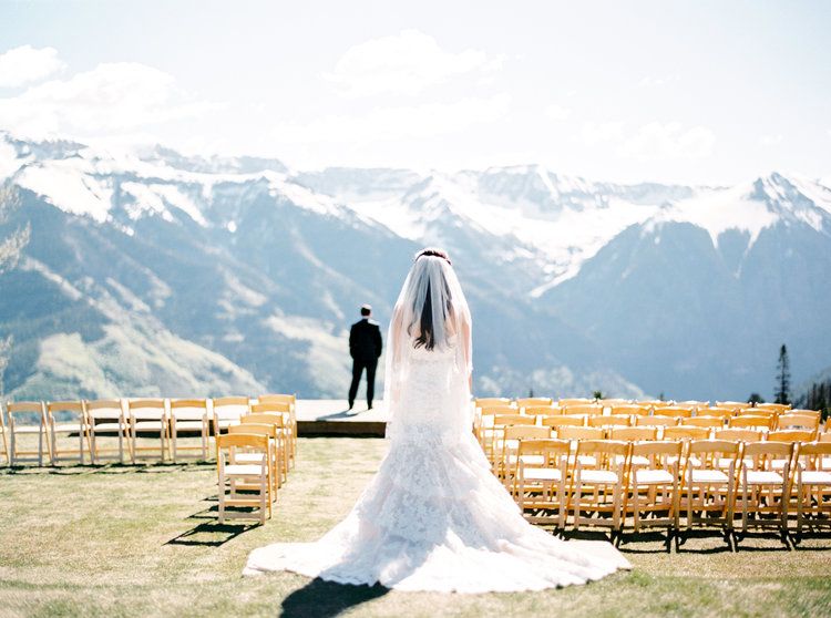 outdoor mountain wedding in colorado bride and groom standing outside in front of view | PartySlate