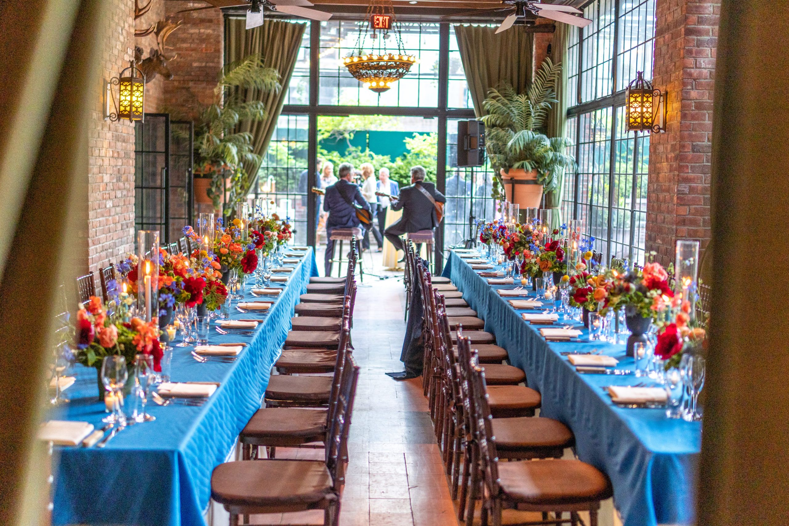blue table cloths at dinner party with floral tablescapes | PartySlate