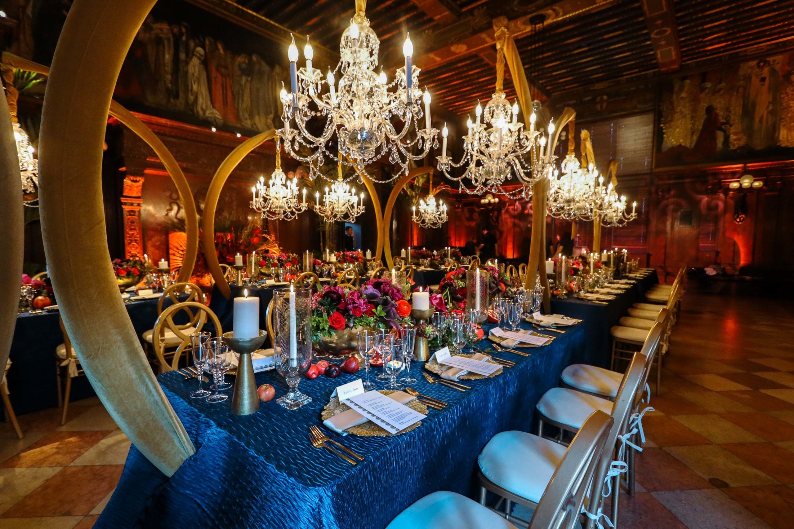 blue table cloths at dinner party with floral tablescapes | PartySlate