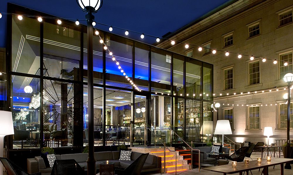Dirty Habit at the Kimpton Hotel Monaco Washington DC with glass windows at the entrance and string lights over the patio | PartySlate