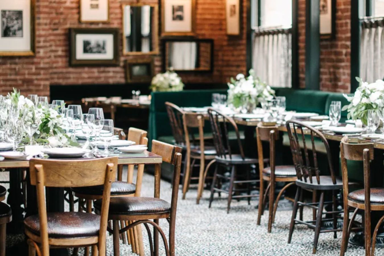 The sequoia room at Wayfare Tavern with green cloth booth seating and floral centerpieces | PartySlate