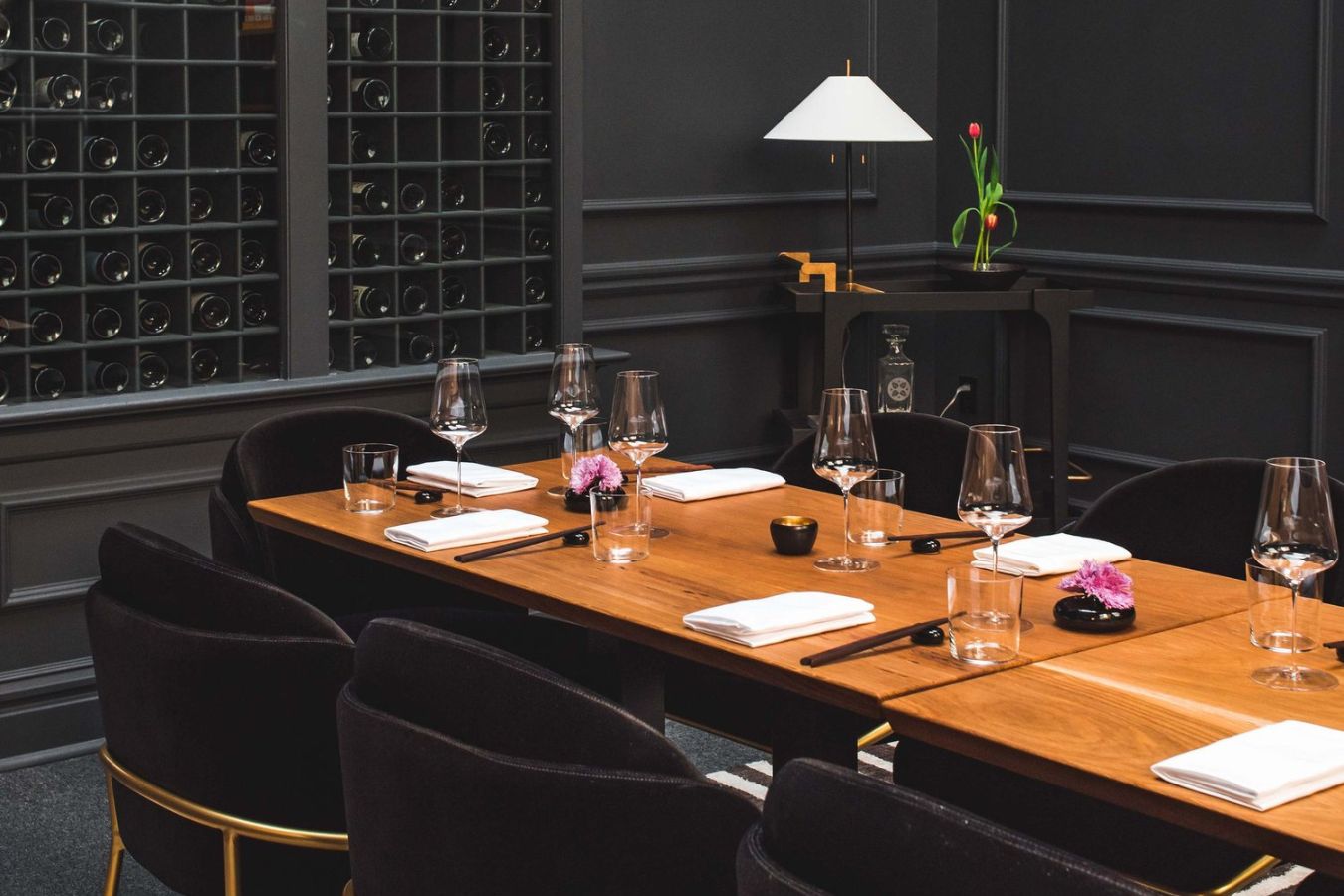 Private dining at Nisei with black walls and wine rack | PartySlate