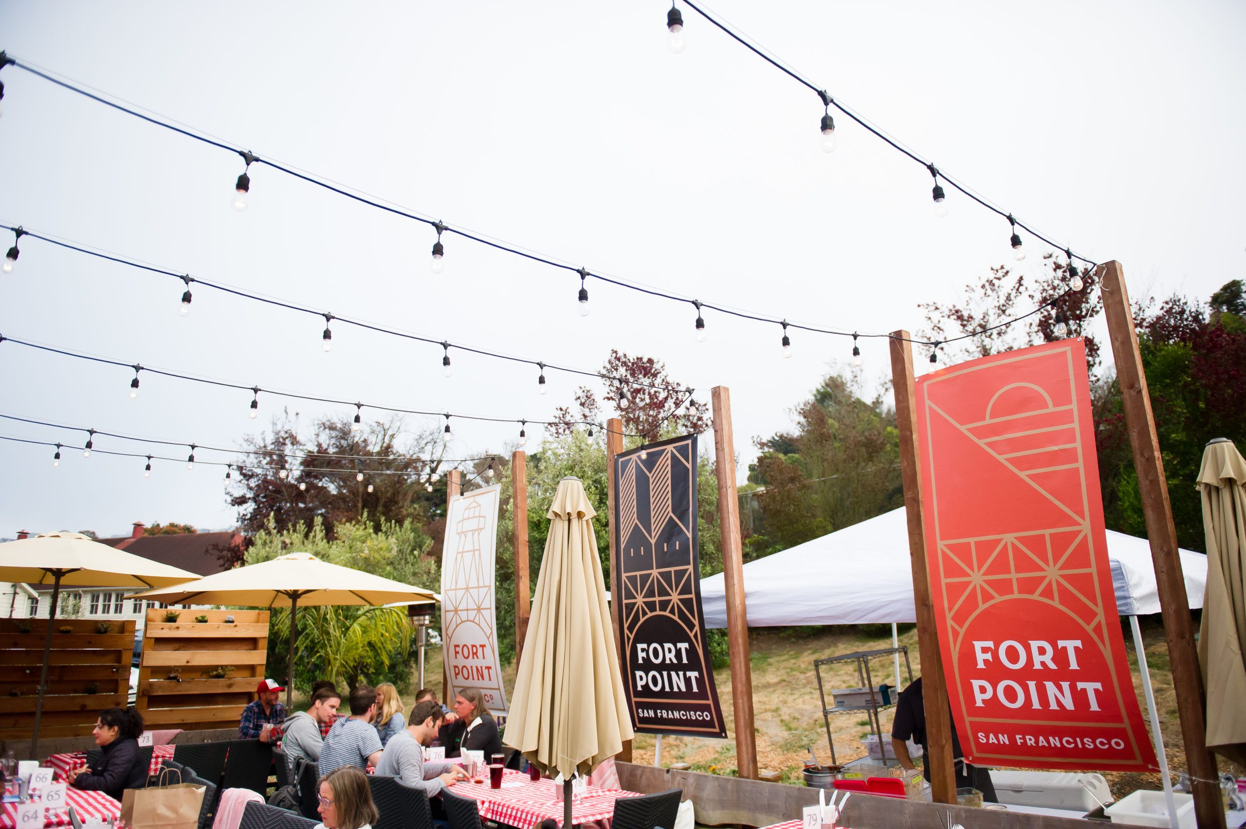 outdoor back patio of Presidio Social Club in San Francisco with space for private dining and string lights hung above the tables | PartySlate