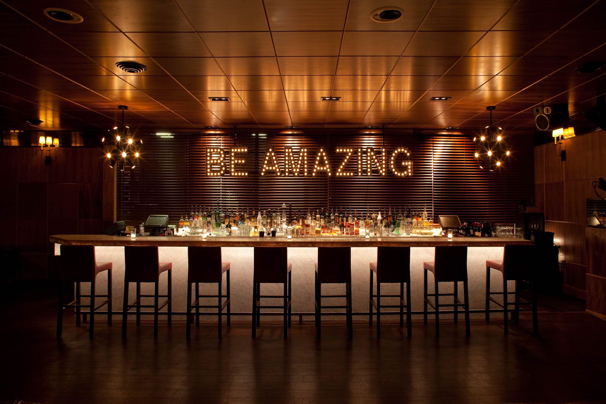 The Lounge at Chambers eat + drink in San Francisco with marquee lights above bar | PartySlate