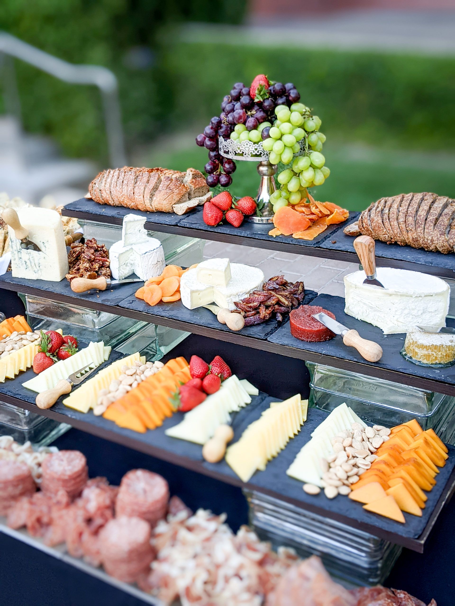 A charcuterie buffet of meats, cheeses, and fruits.