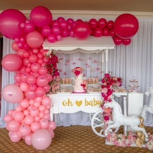 Pink baby shower balloon installation over cake cart | PartySlate