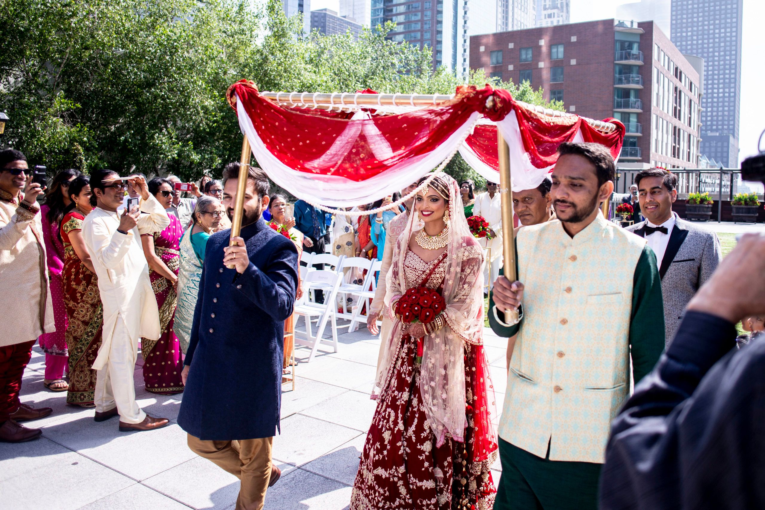 Bride is escorted to Mandap under red and white canopy during Kanya Aagaman | PartySlate
