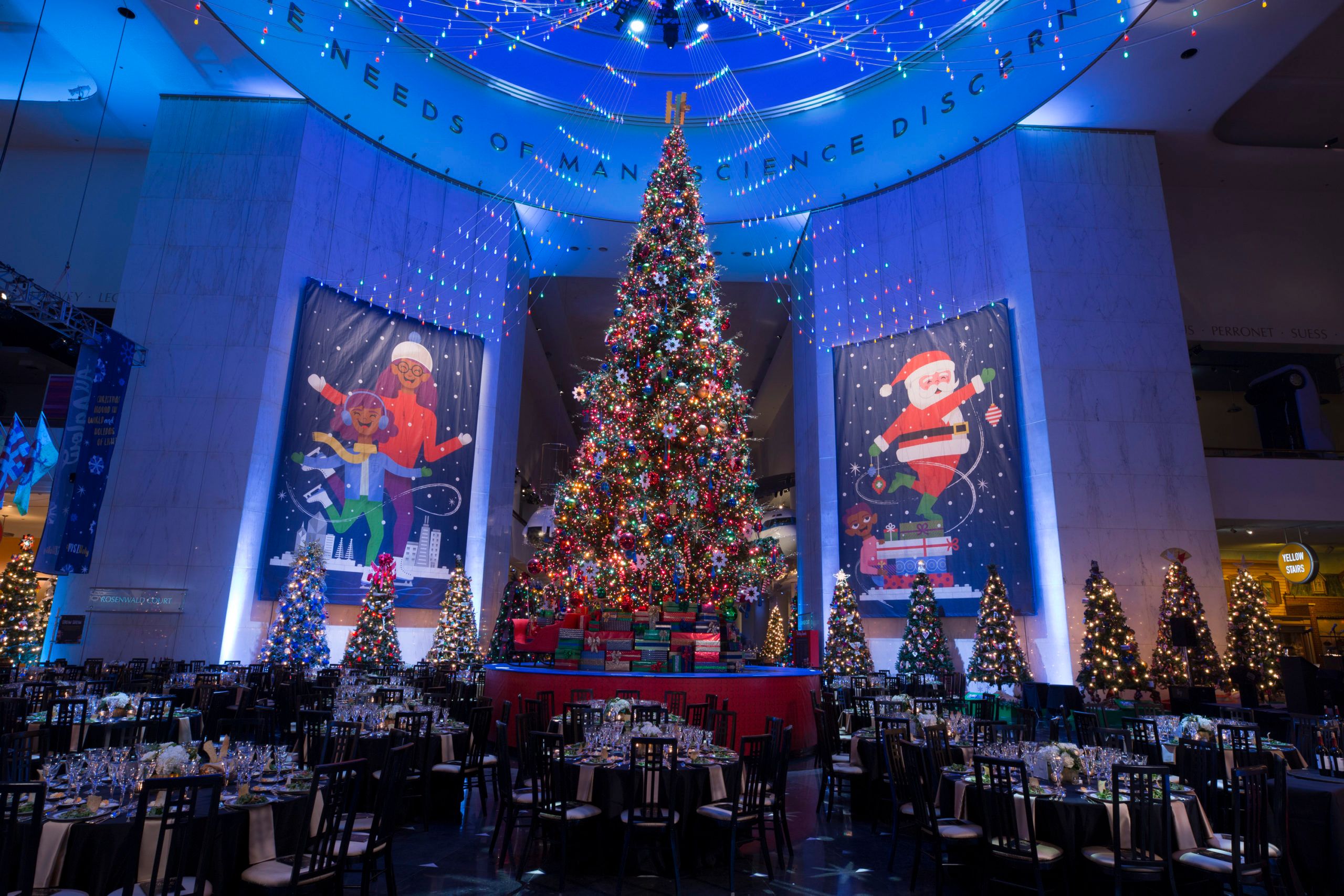 Corporate holiday party at Museum of Science and Industry with Giant Christmas Tree and Blue Uplighting | PartySlate