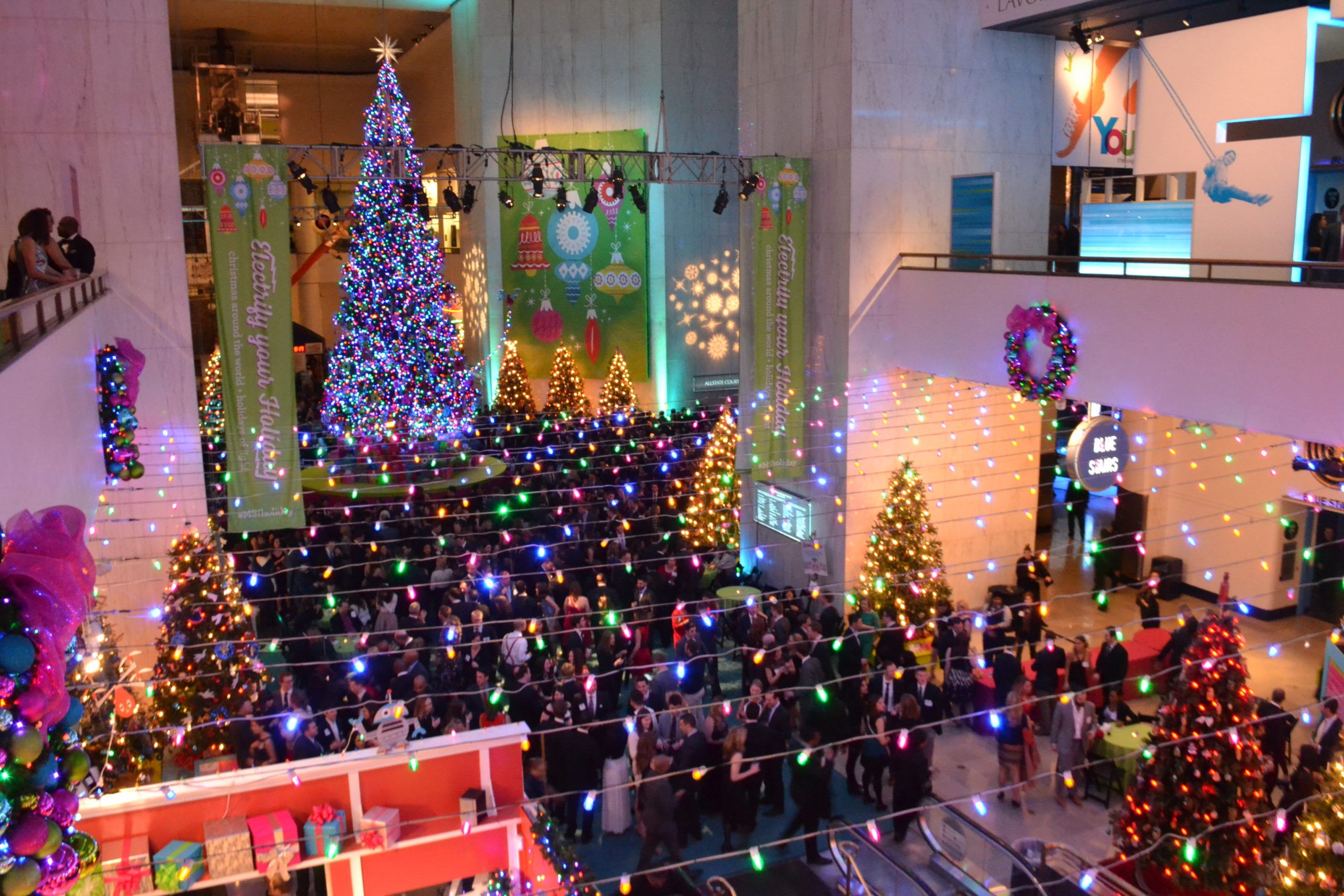 Corporate Holiday Party Venue Decorated With Giant Christmas Tree and Colorful String Lights | PartySlate