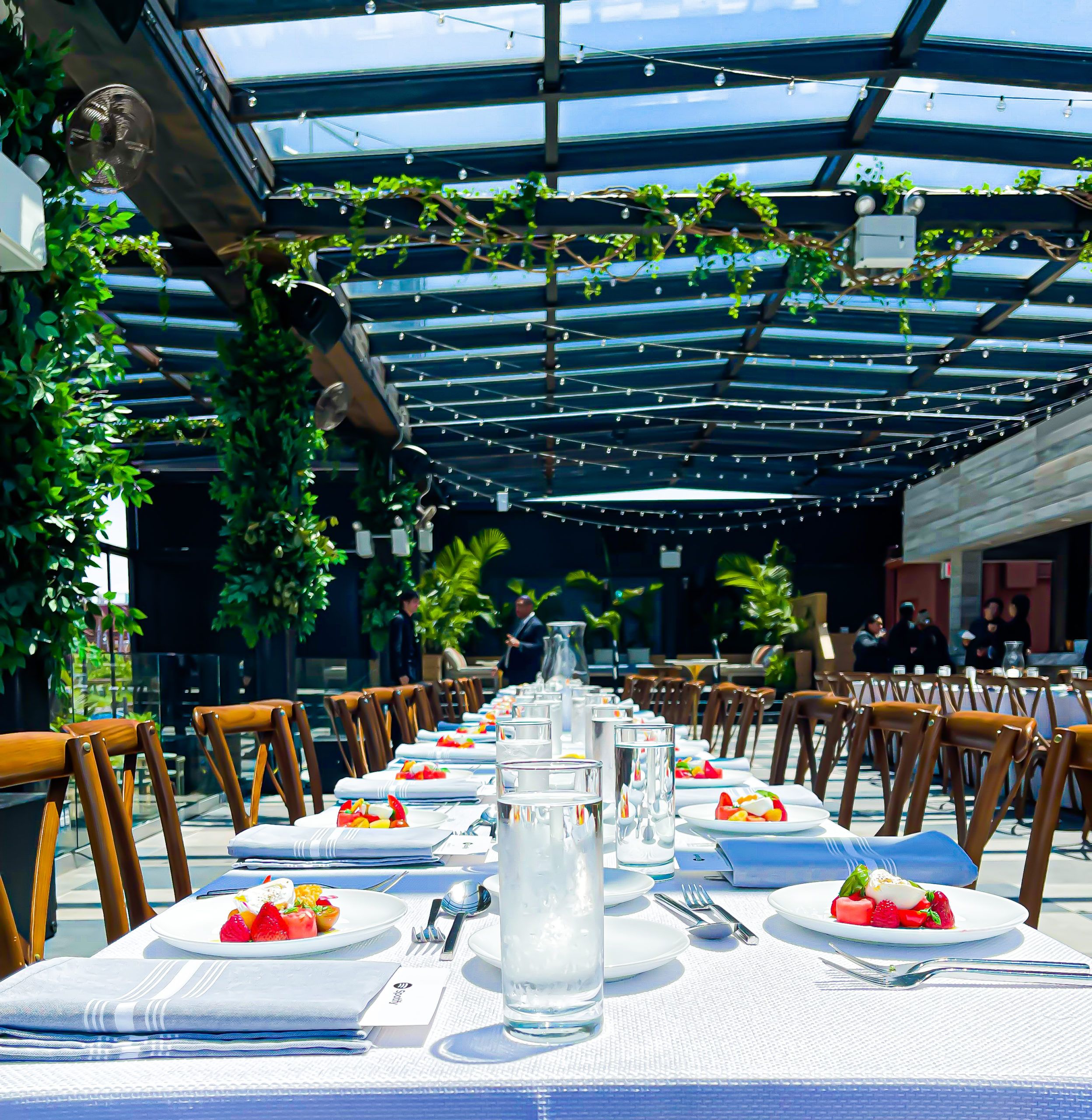 A white tablescape in a setting with lots of greenery.