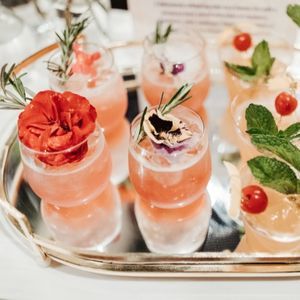 Pink cocktail with lush botanical garnishes | PartySlate