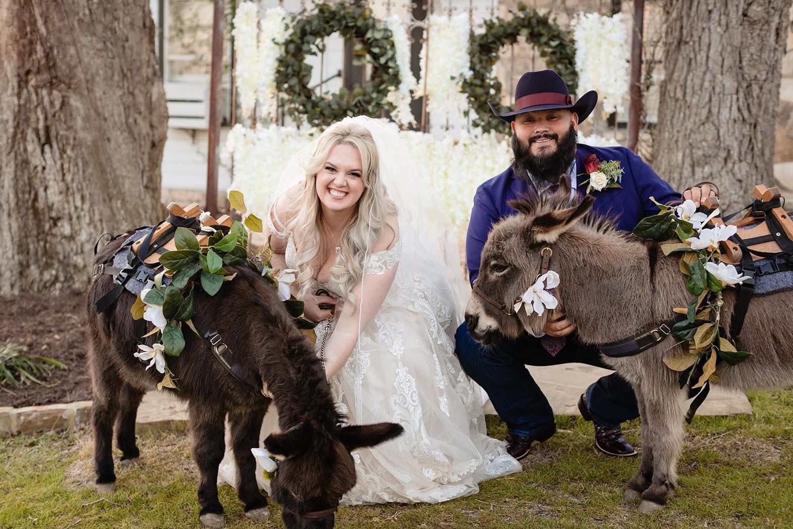 wedding at Pecan Springs Ranch couples posing with donkeys on the property | PartySlate
