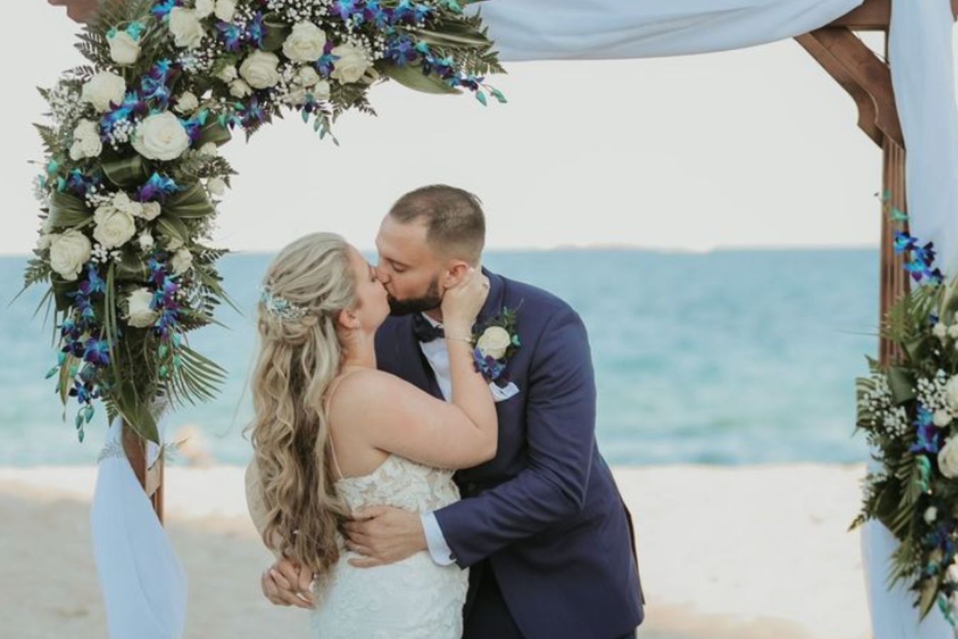 Wedding couple at B Ocean Resort Fort Lauderdale with blue wedding floral arch | PartySlate