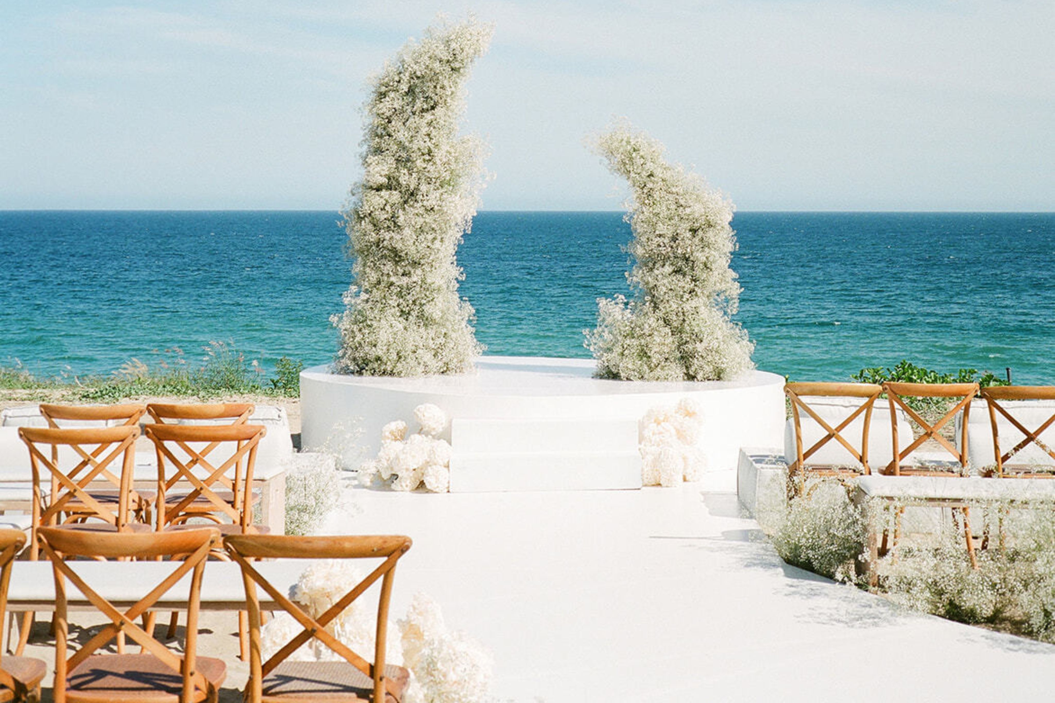 Beach wedding with asymmetrical floral wedding arch.