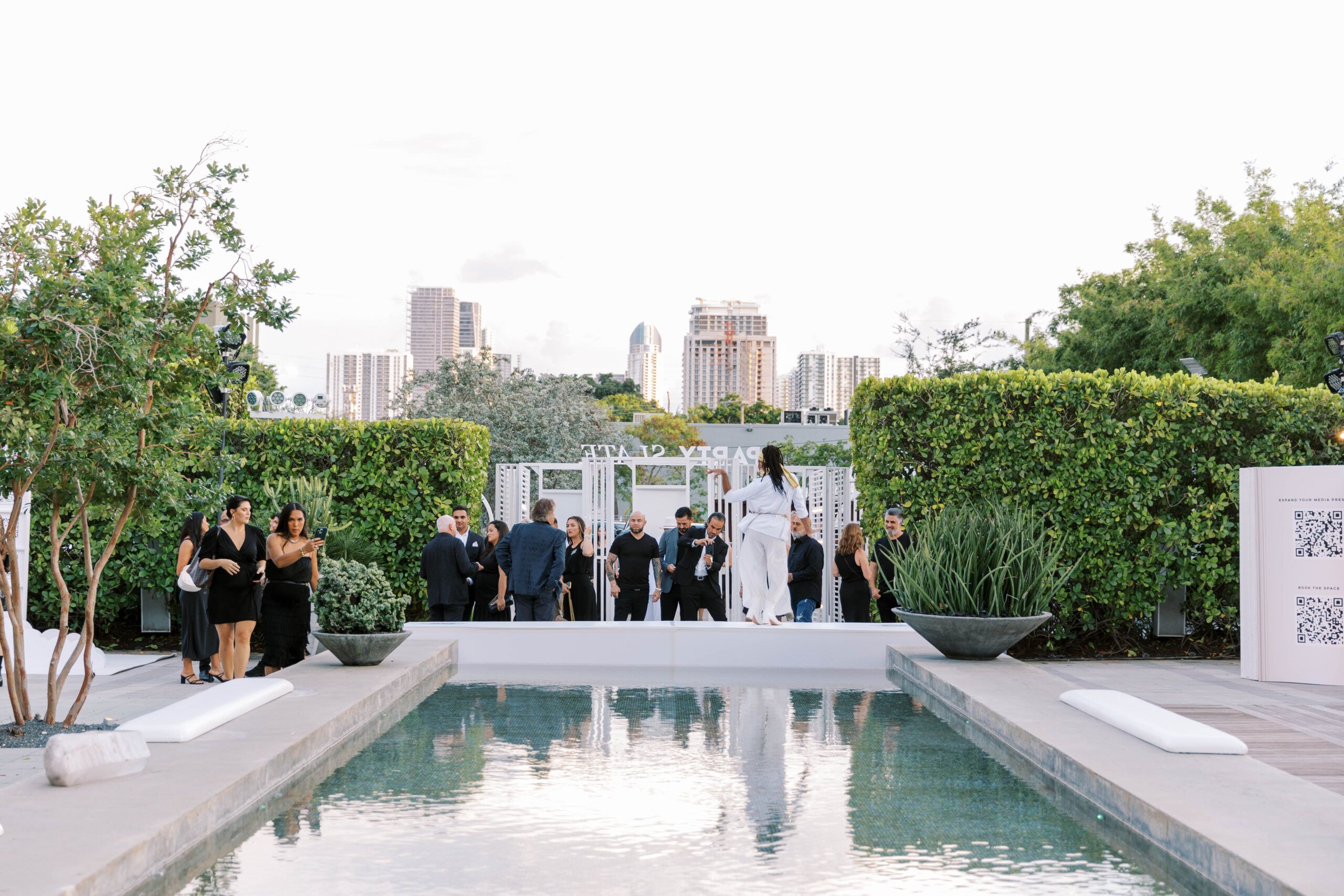 A wide shot of the party with a pool in the city
