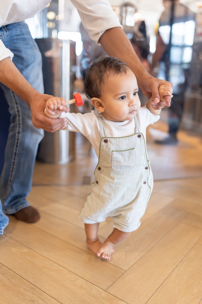 Dad helping baby take first steps at The Little Play Avenue