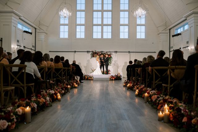 Featured photo from This Providence Vineyard Wedding Featured Crimson Tablescapes, Floral-Draped Walls, and a White Barn Ceremony