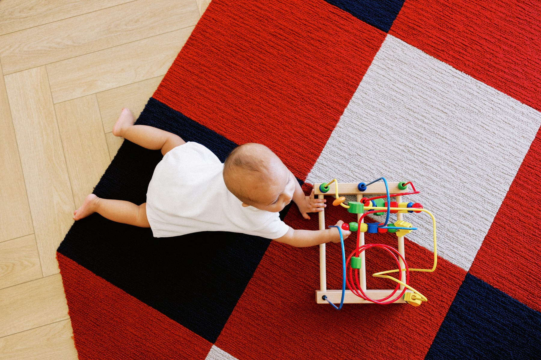 A baby reaching for a sensory bead maze at The Little Play Avenue