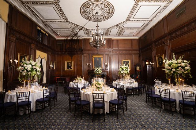 Featured photo from Discover This Candlelit Wedding at The Union League Club with Tall White Centerpieces and Rich Wood Paneling