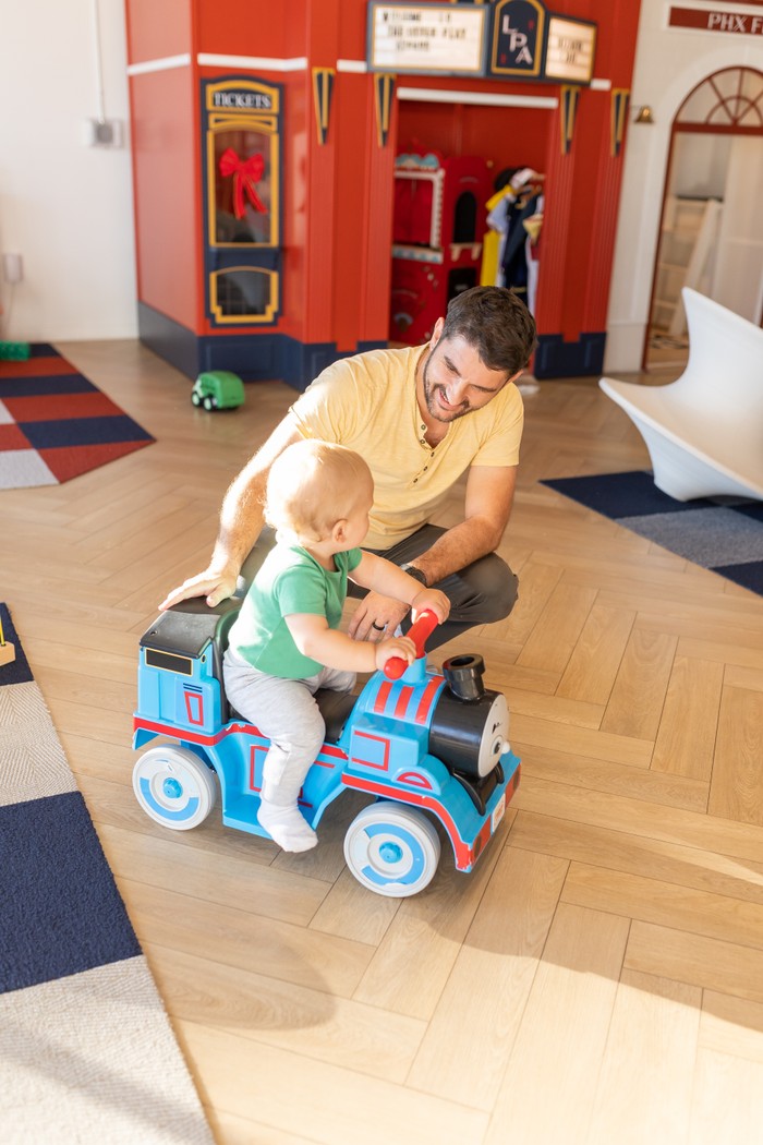 Dad playing with toddler on ride-on train at TLPA